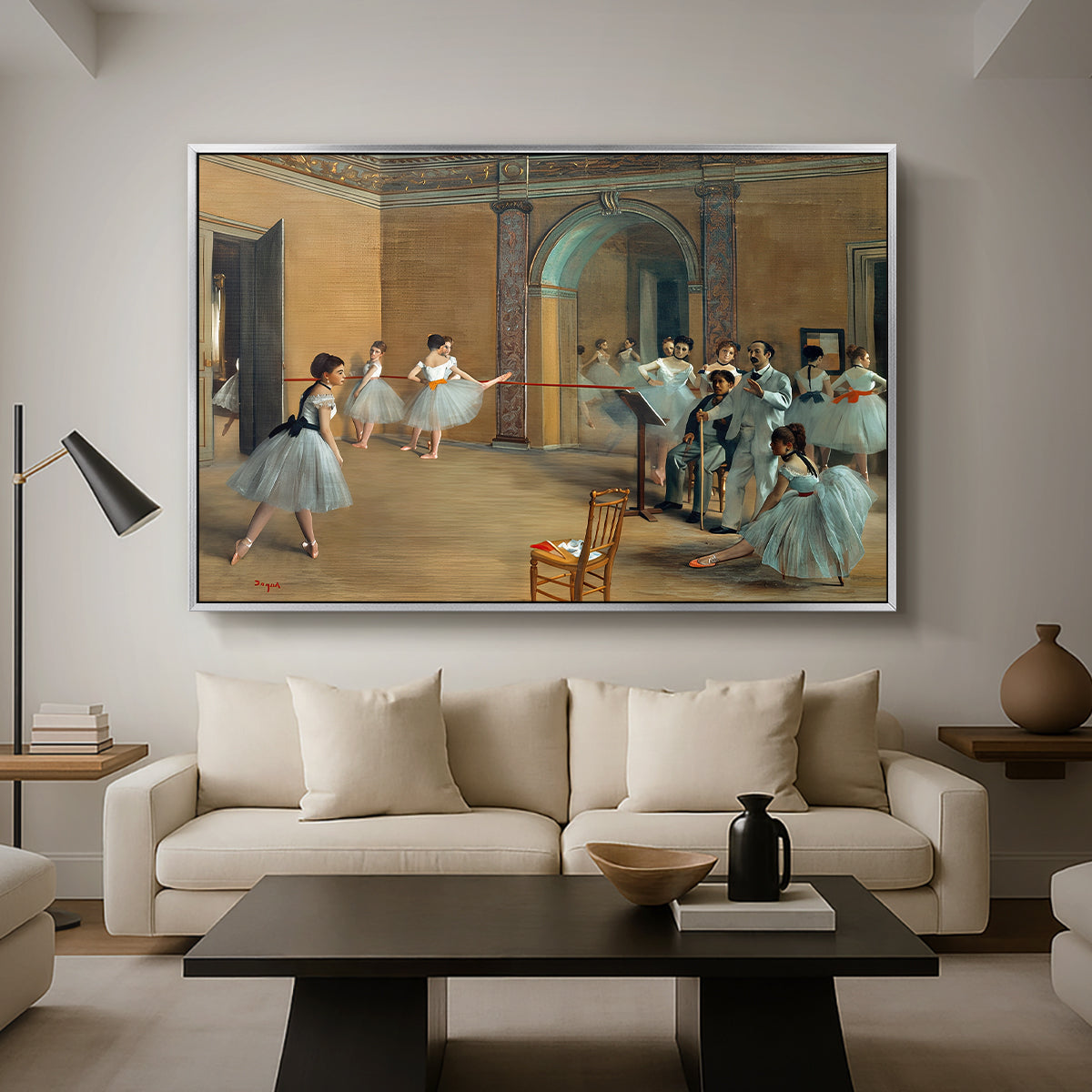 The Dance Foyer at the Opera on the Rue Le Peletier, 1872 by Edgar Degas as a silver floater framed canvas featuring ballet dancers gathered in rehearsal hall with mirrors and columns, displayed above a sofa in a modern living room.