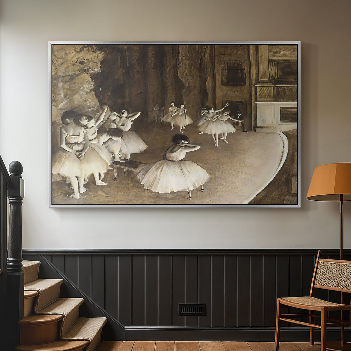 Silver floater framed canvas featuring dancers arranged on stage with visible set and depth, displayed in a hallway near a staircase.