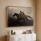 Silver floater framed canvas of A Ride for Liberty – The Fugitive Slaves, c. 1862 by Eastman Johnson, featuring a dramatic scene of enslaved people fleeing on horseback in darkness above a console cabinet in a minimalist entryway.