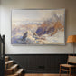 Silver floater framed canvas featuring a rugged mountain pass scene with distant peaks, displayed in a hallway near a staircase.