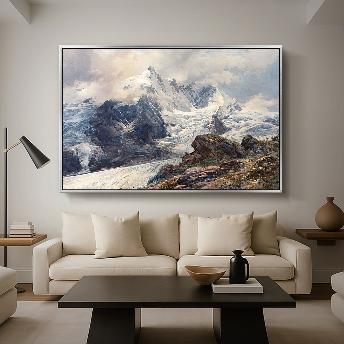 The Grossglockner, 1880 by Edward Theodore Compton as a silver floater framed canvas featuring a towering mountain peak rising above rocky alpine landscape, displayed above a sofa in a modern living room.