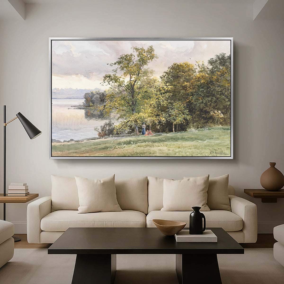 Landscape at Lake Starnberg, 1890 by Edward Theodore Compton as a silver floater framed canvas featuring a lakeside landscape with calm water and trees along shoreline, displayed above a sofa in a modern living room.