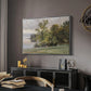 Landscape at Lake Starnberg, 1890 by Edward Theodore Compton in a silver floater framed canvas featuring a natural setting with water, trees, and open sky, displayed above a desk in a dark home office interior.