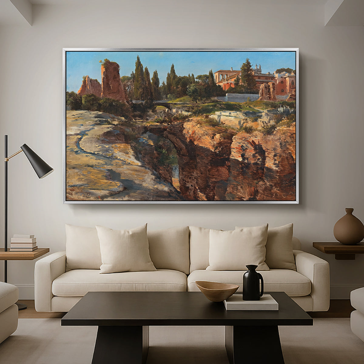 Palatine in Rome, c. 1921 by Edward Theodore Compton as a silver floater framed canvas featuring historic Roman ruins and buildings set within warm landscape, displayed above a sofa in a modern living room.