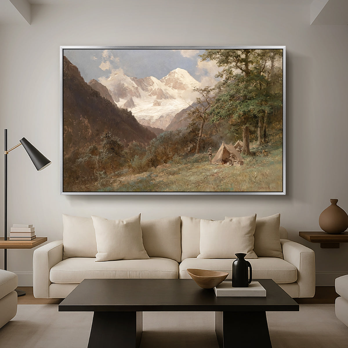 Landscape in the Caucasus, c. 1921 by Edward Theodore Compton as a silver floater framed canvas featuring a mountainous landscape with rugged terrain and distant peaks, displayed above a sofa in a modern living room.