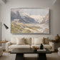 Shepherds (Pasterze), c. 1921 by Edward Theodore Compton as a silver floater framed canvas featuring a small group of shepherds in alpine landscape with grazing animals, displayed above a sofa in a modern living room.