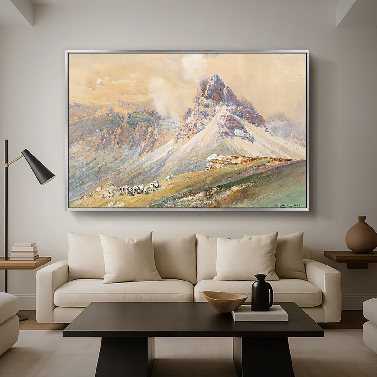 From the Dolomites, 1904 by Edward Theodore Compton as a silver floater framed canvas featuring dramatic Dolomite mountain peaks rising above rugged terrain, displayed above a sofa in a modern living room.