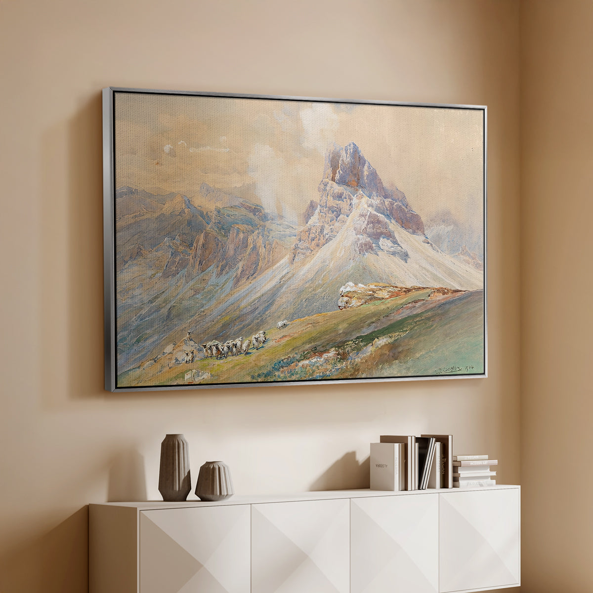 Silver floater framed canvas of From the Dolomites, 1904 by Edward Theodore Compton, featuring an alpine scene with jagged rock formations and distant mountains above a console cabinet in a minimalist entryway.