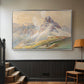 Silver floater framed canvas featuring a realistic mountain view with strong geological forms, displayed in a hallway near a staircase.