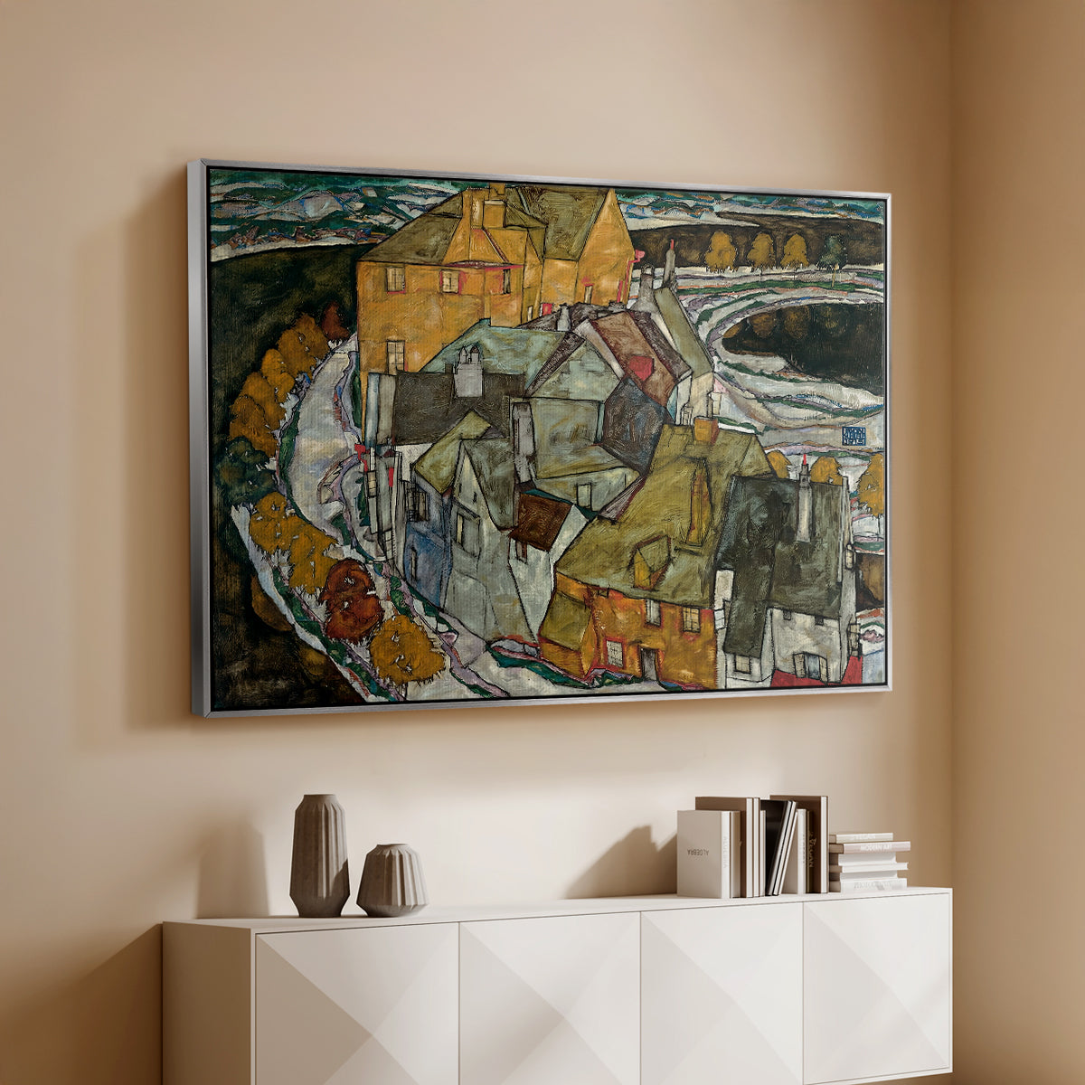 Silver floater framed canvas of Crescent of Houses II (Island Town), 1915 by Egon Schiele, featuring a stylized townscape with clustered buildings and bold outlines above a console cabinet in a minimalist entryway.