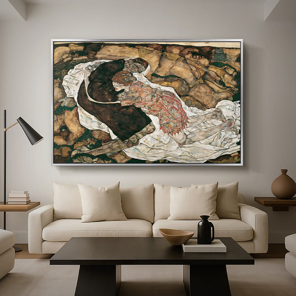 Death and the Maiden, 1915 by Egon Schiele as a silver floater framed canvas featuring intertwined figures representing death and woman in emotional embrace, displayed above a sofa in a modern living room.