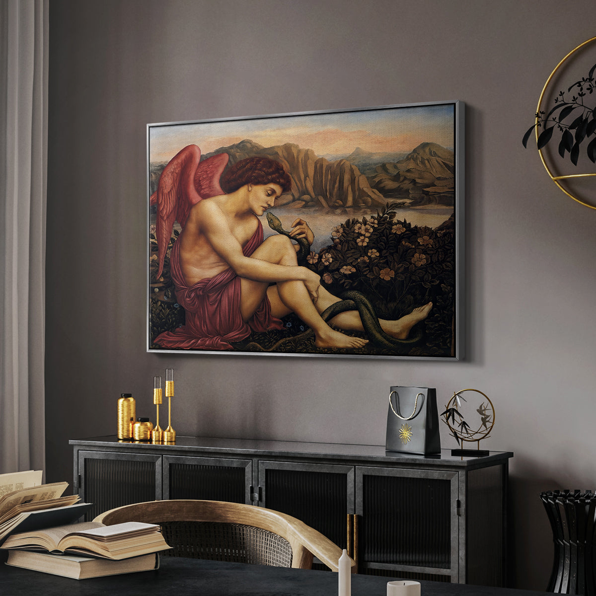 The Angel with the Serpent, c. 1870-1875 by Evelyn De Morgan in a silver floater framed canvas featuring a religious scene with angel defeating snake in dramatic pose, displayed above a desk in a dark home office interior.