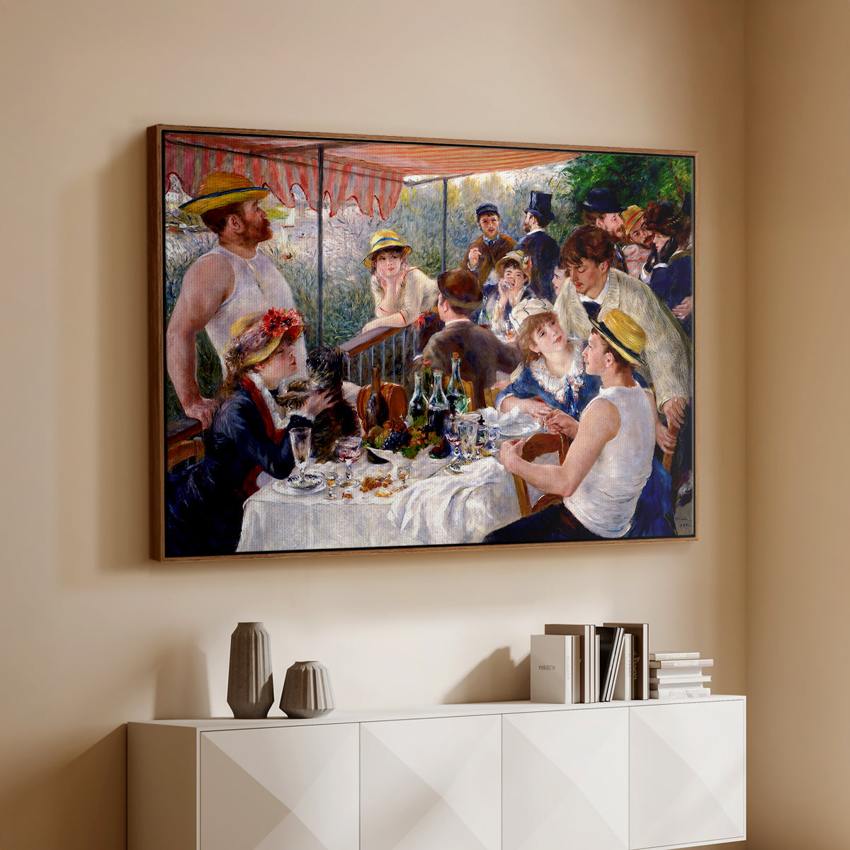Walnut floater framed canvas of Luncheon of the Boating Party (Le Déjeuner des canotiers), 1880-1881 by Pierre-Auguste Renoir, featuring a lively gathering of men and women eating and socializing at outdoor table above a console cabinet in a minimalist entryway.