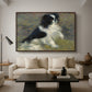 Tama, the Japanese Dog, c. 1876 by Pierre-Auguste Renoir as a walnut floater framed canvas featuring a small black and white dog standing in shallow water with soft brushstrokes, displayed above a sofa in a modern living room.
