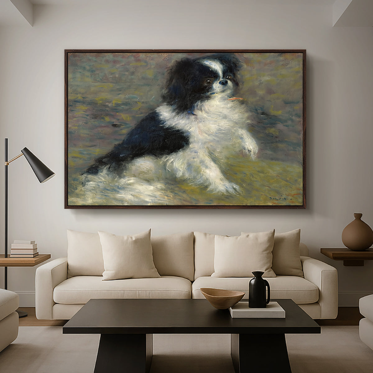 Tama, the Japanese Dog, c. 1876 by Pierre-Auguste Renoir as a walnut floater framed canvas featuring a small black and white dog standing in shallow water with soft brushstrokes, displayed above a sofa in a modern living room.