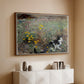Walnut floater framed canvas of Cat on a Flowery Meadow, 1887 by Bruno Liljefors, featuring a small cat resting among colorful flowers in grassy field above a console cabinet in a minimalist entryway.