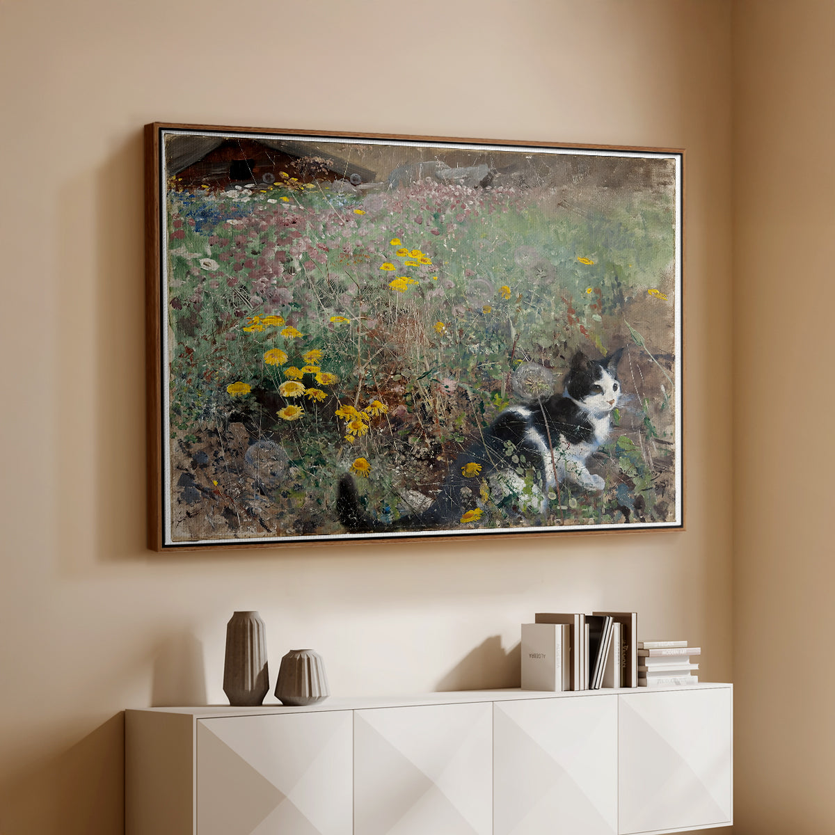 Walnut floater framed canvas of Cat on a Flowery Meadow, 1887 by Bruno Liljefors, featuring a small cat resting among colorful flowers in grassy field above a console cabinet in a minimalist entryway.