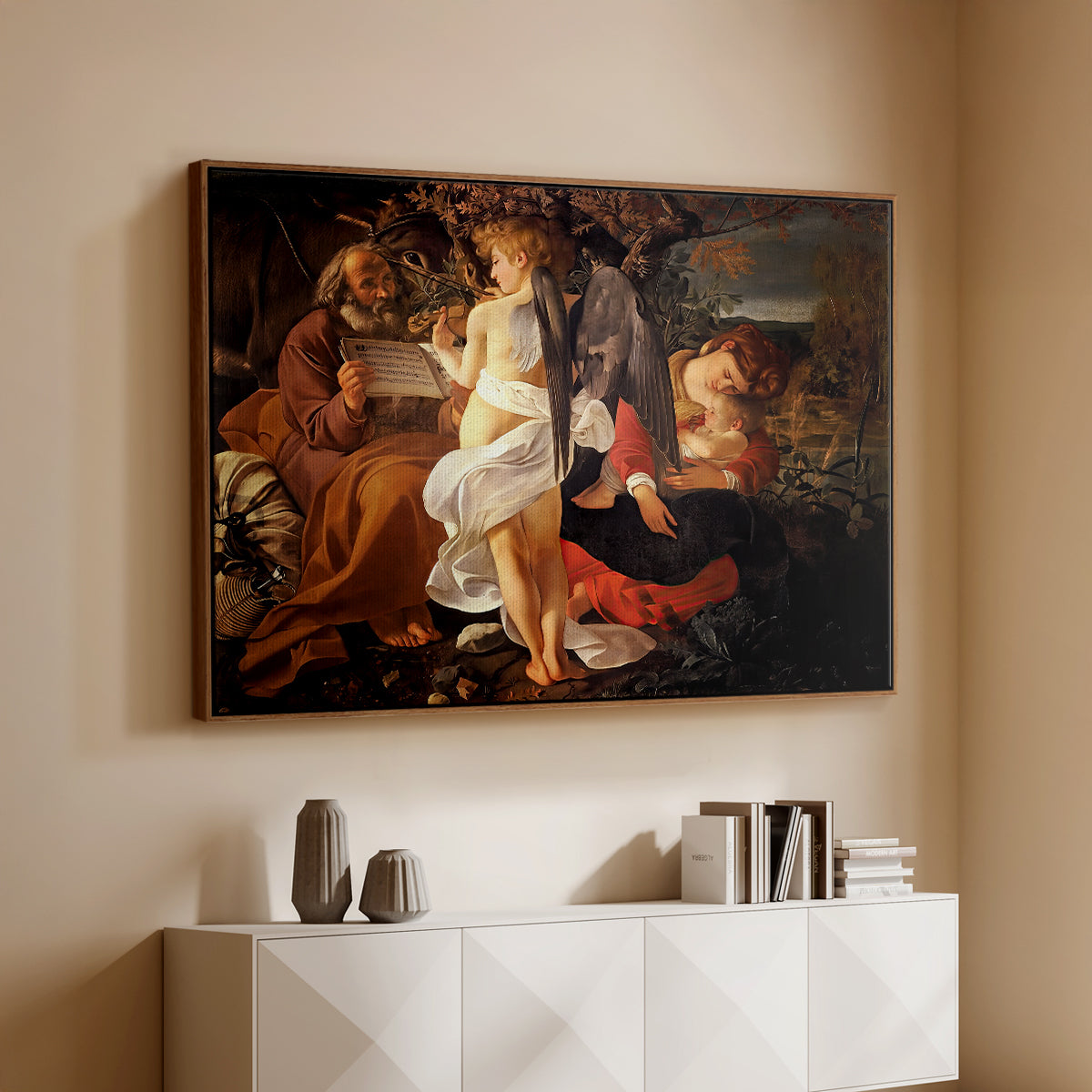 Walnut floater framed canvas of Rest on the Flight into Egypt, c. 1597 by Caravaggio, featuring a biblical scene of Mary, Joseph, and infant resting with angel musician above a console cabinet in a minimalist entryway.
