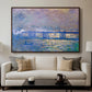 Charing Cross Bridge, 1903 by Claude Monet displayed in a walnut floater framed canvas above a sofa in a clean living room.