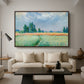 The Wheat Field (Champ de Blé), 1881 by Claude Monet as a walnut floater framed canvas featuring a golden wheat field stretching across landscape under soft sky, displayed above a sofa in a modern living room.