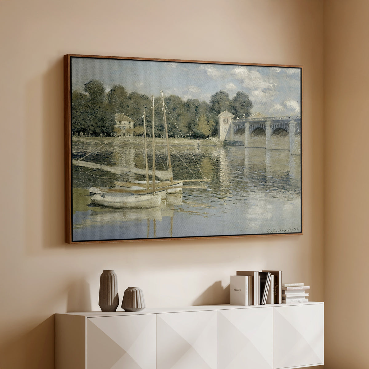 Walnut floater framed canvas of The Bridge at Argenteuil, 1874 by Claude Monet, featuring an impressionist river scene with boats passing beneath bridge above a console cabinet in a minimalist entryway.