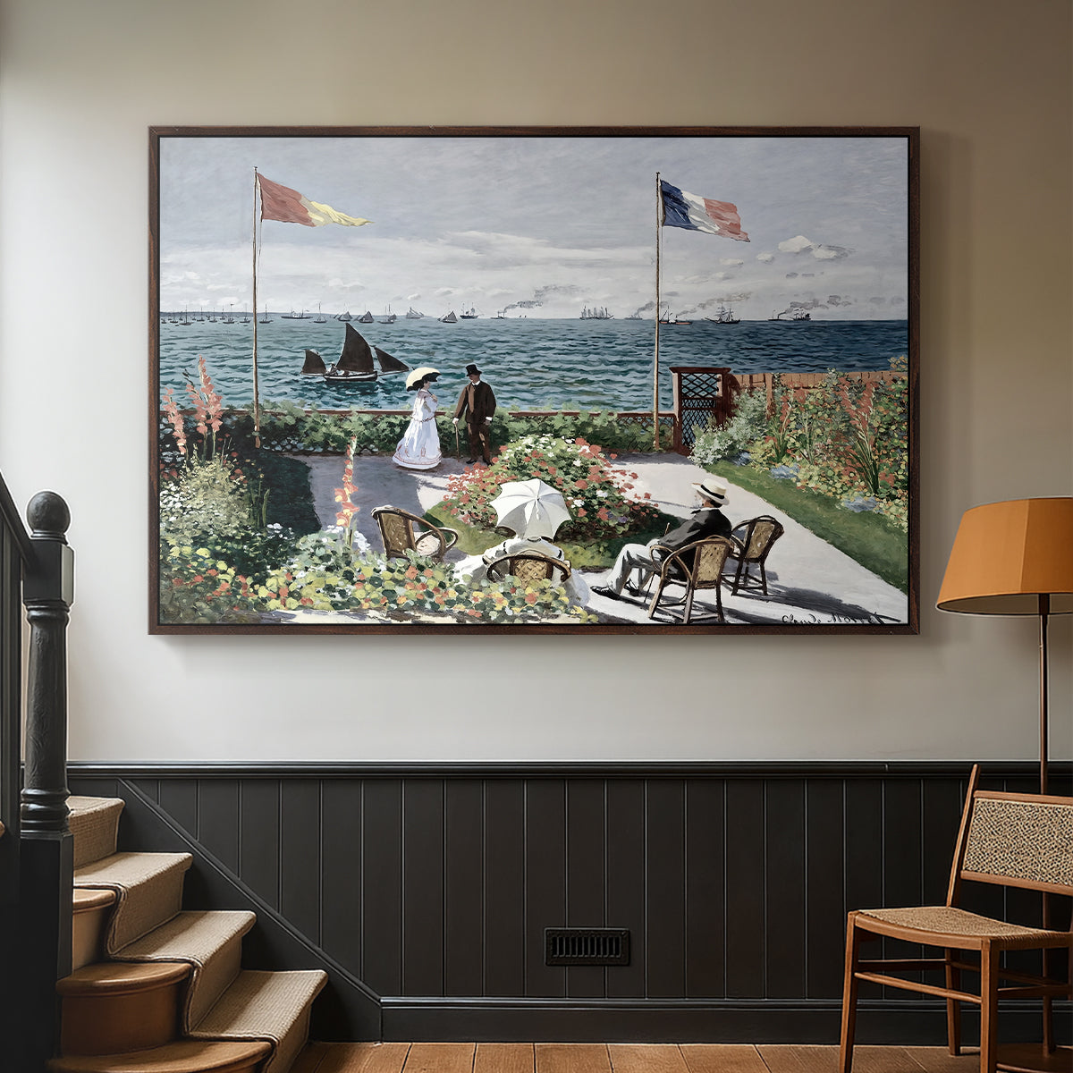Walnut floater framed canvas featuring a landscaped terrace with figures and flags near shoreline, displayed in a hallway near a staircase.