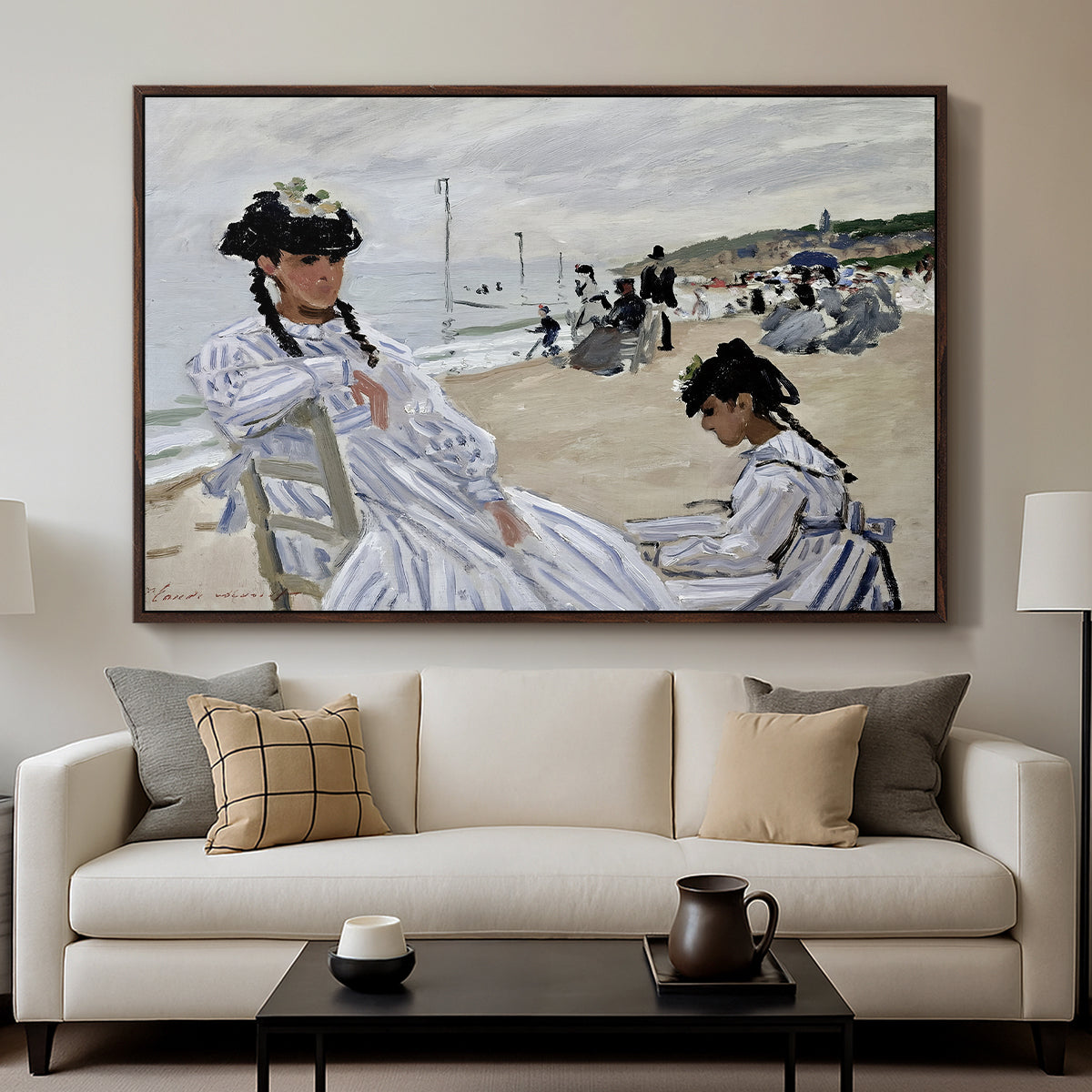 On the Beach at Trouville, 1870 by Claude Monet displayed in a walnut floater framed canvas above a sofa in a clean living room.