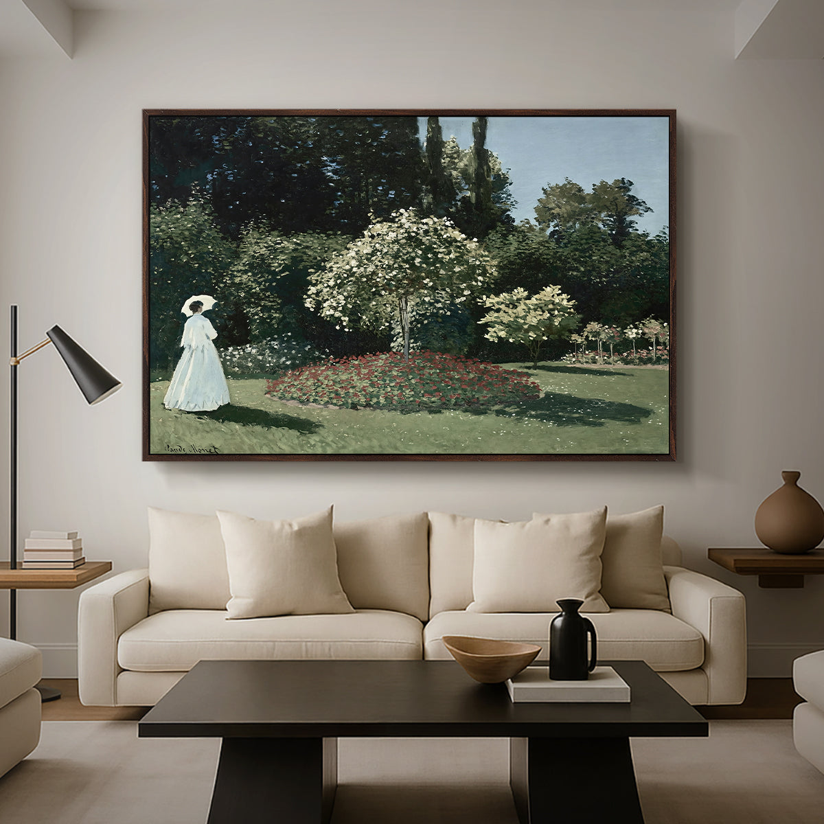 Woman in the Garden, Sainte-Adresse, 1867 by Claude Monet as a walnut floater framed canvas featuring a woman standing in garden surrounded by flowers and greenery, displayed above a sofa in a modern living room.