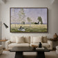 Summer (L'ete), 1874 by Claude Monet as a walnut floater framed canvas featuring a woman seated in grassy field beneath tree in bright summer landscape, displayed above a sofa in a modern living room.