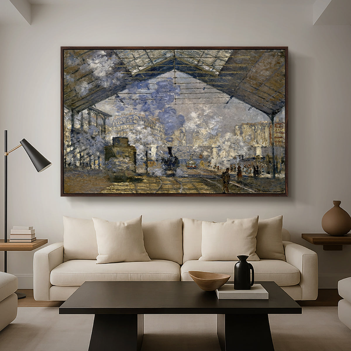The Gare Saint-Lazare, 1877 by Claude Monet as a walnut floater framed canvas featuring a train station interior filled with steam and locomotives under iron structure, displayed above a sofa in a modern living room.