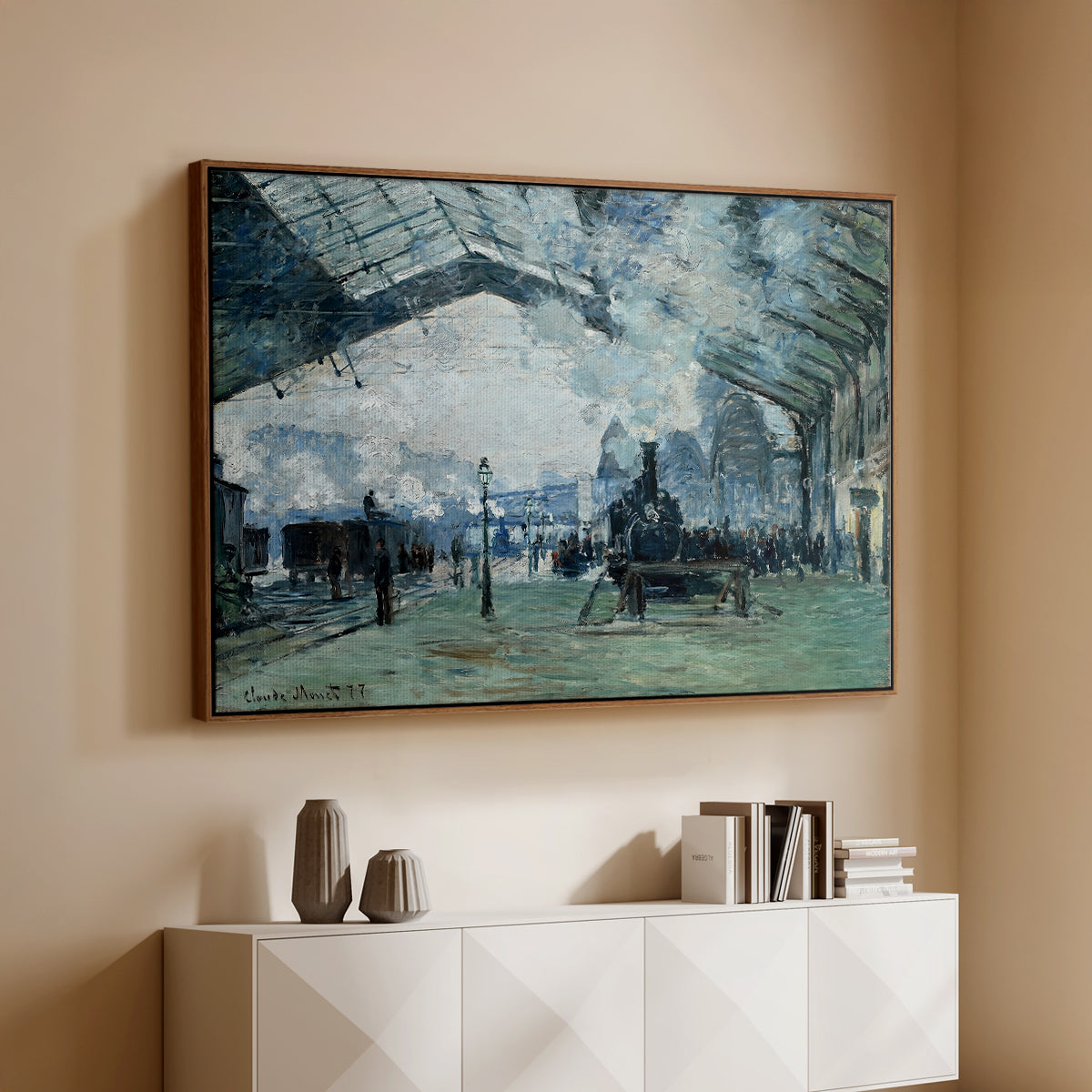 Walnut floater framed canvas of The Saint-Lazare Station, 1877 by Claude Monet, featuring an impressionist railway scene with locomotives and haze above a console cabinet in a minimalist entryway.