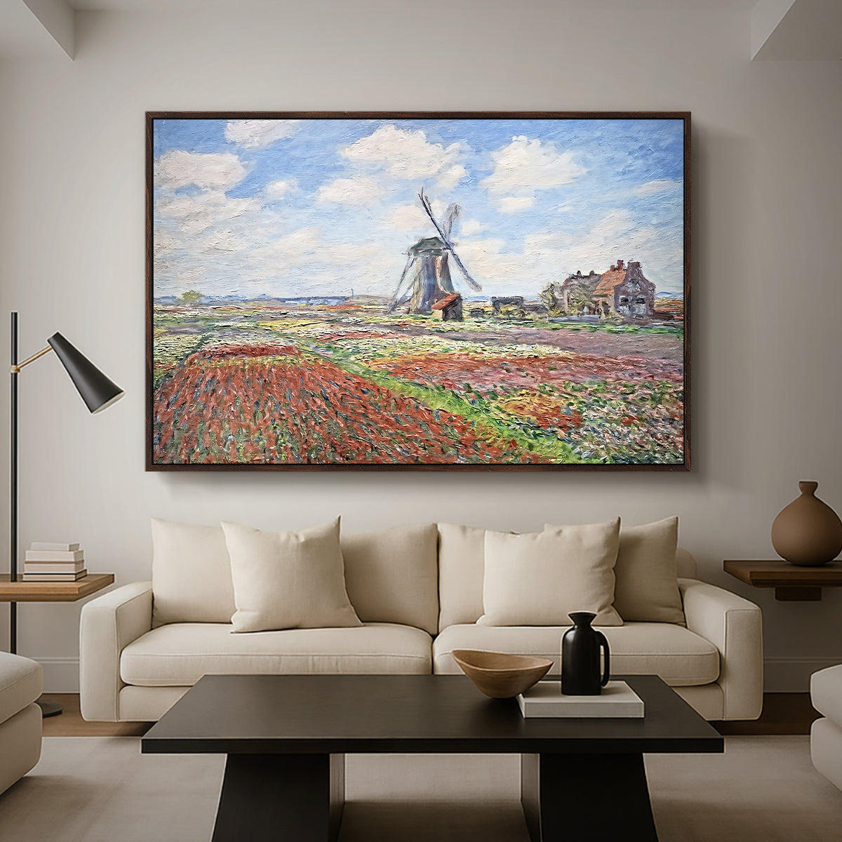 Tulip Fields with the Rijnsburg Windmill, 1886 by Claude Monet as a walnut floater framed canvas featuring colorful rows of tulip fields leading toward distant windmill, displayed above a sofa in a modern living room.