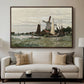 Windmill at Zaandam, 1871 by Claude Monet displayed in a walnut floater framed canvas above a sofa in a clean living room.