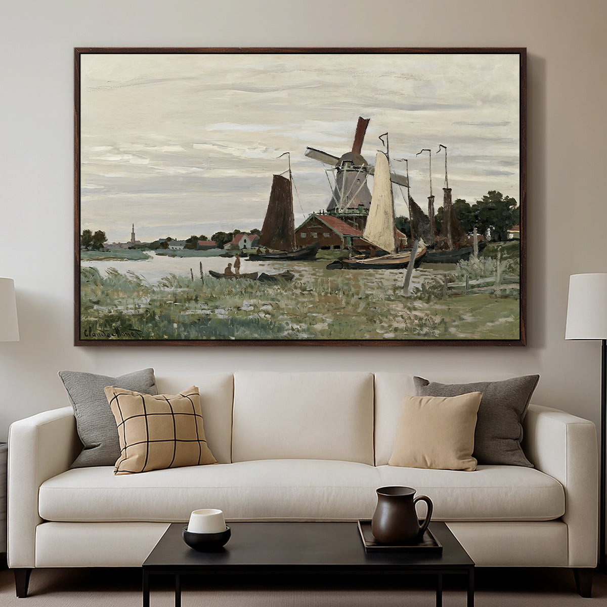 Windmill at Zaandam, 1871 by Claude Monet displayed in a walnut floater framed canvas above a sofa in a clean living room.