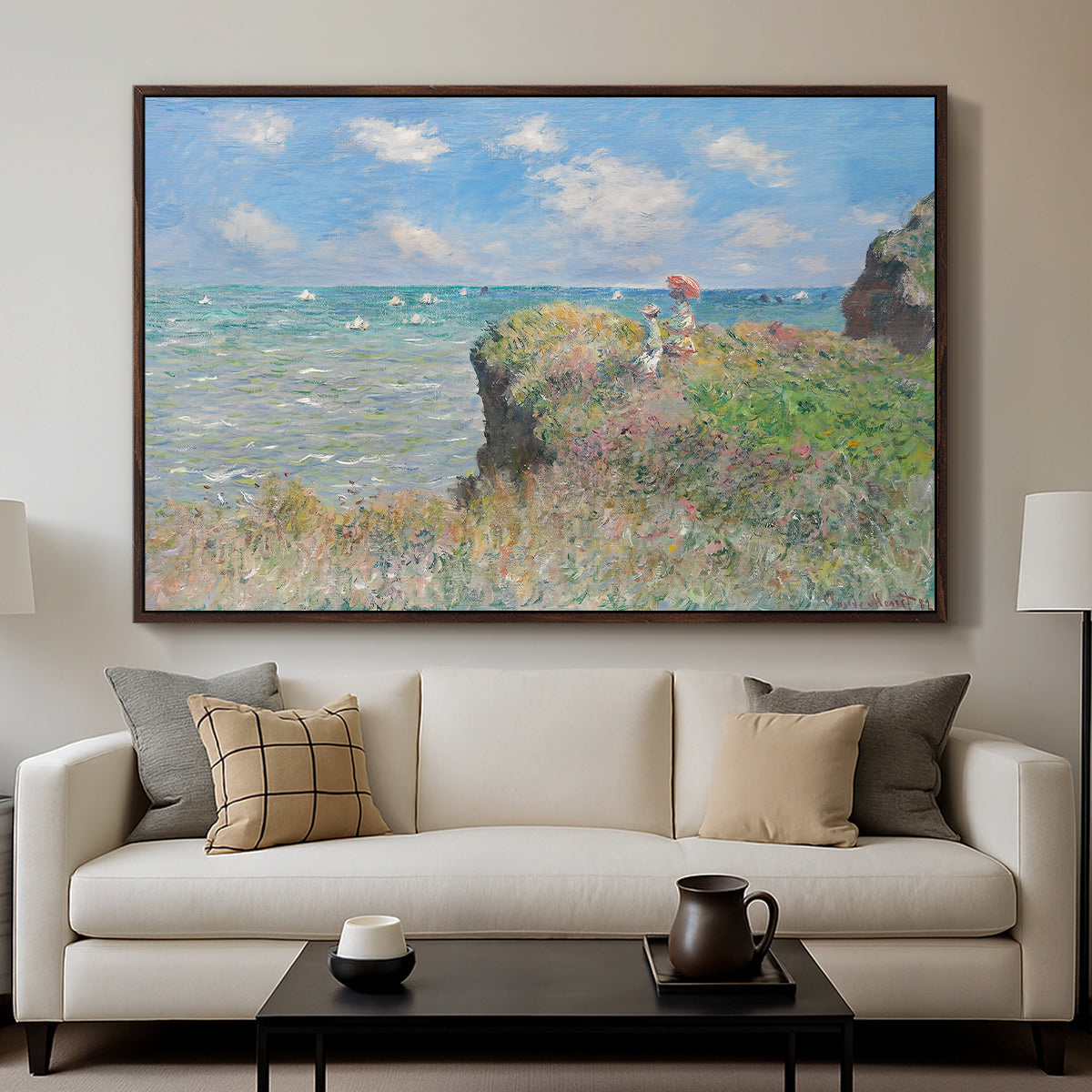 The Cliff Walk at Pourville, 1882 by Claude Monet displayed in a walnut floater framed canvas above a sofa in a clean living room.
