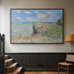 Walnut floater framed canvas featuring an elevated shoreline path with figures and bright sky, displayed in a hallway near a staircase.