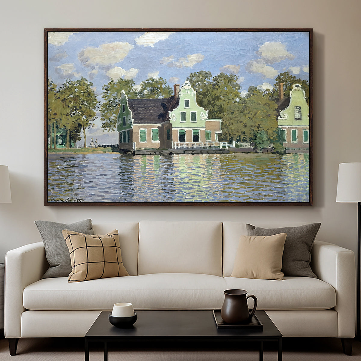Houses on the Zaan River at Zaandam, 1871 by Claude Monet displayed in a walnut floater framed canvas above a sofa in a clean living room.