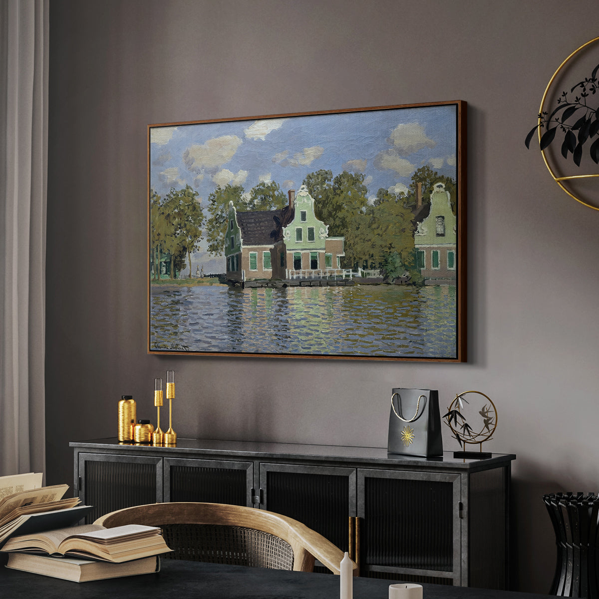 Houses on the Zaan River at Zaandam, 1871 by Claude Monet in a walnut floater framed canvas featuring a peaceful canal scene with houses mirrored in water, displayed above a desk in a dark home office interior.