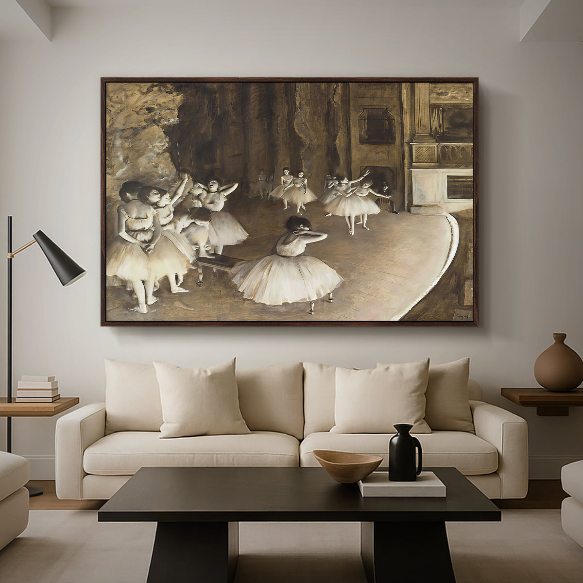 The Rehearsal of the Ballet Onstage, 1874 by Edgar Degas as a walnut floater framed canvas featuring ballerinas rehearsing on stage with set backdrop and lighting, displayed above a sofa in a modern living room.