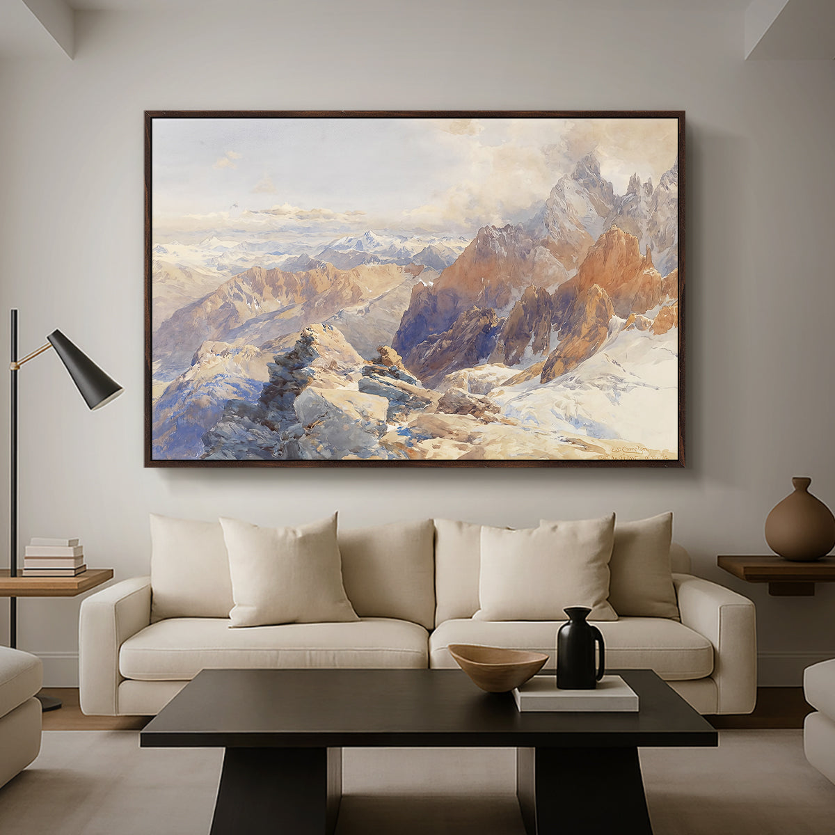 Col du Géant, 1903 by Edward Theodore Compton as a walnut floater framed canvas featuring a mountain pass with snow-covered peaks and expansive alpine valley, displayed above a sofa in a modern living room.