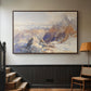 Walnut floater framed canvas featuring a rugged mountain pass scene with distant peaks, displayed in a hallway near a staircase.