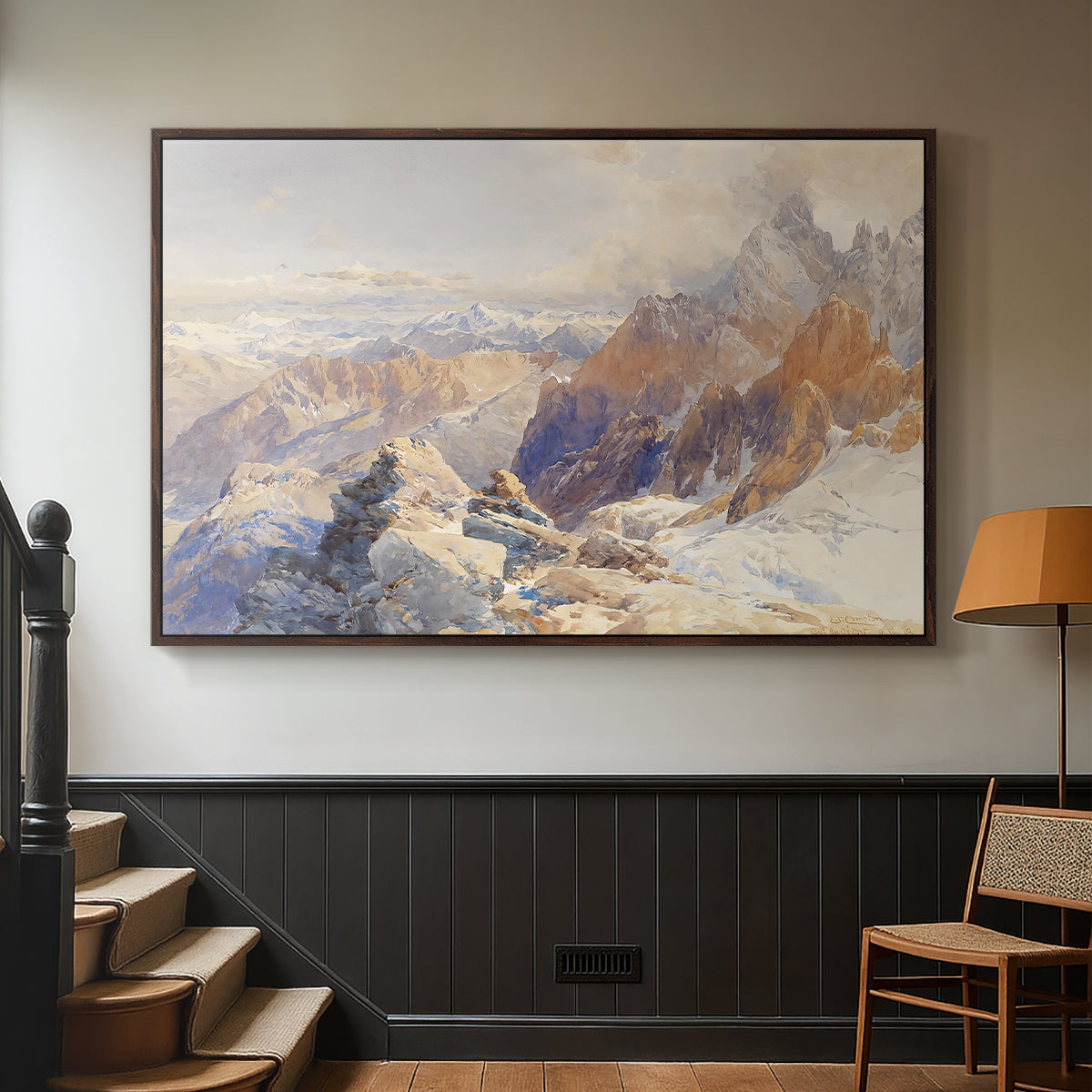 Walnut floater framed canvas featuring a rugged mountain pass scene with distant peaks, displayed in a hallway near a staircase.