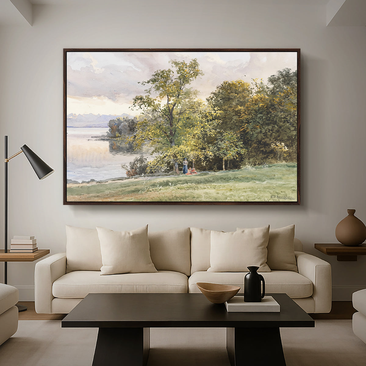 Landscape at Lake Starnberg, 1890 by Edward Theodore Compton as a walnut floater framed canvas featuring a lakeside landscape with calm water and trees along shoreline, displayed above a sofa in a modern living room.