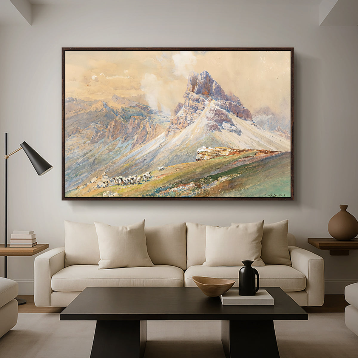 From the Dolomites, 1904 by Edward Theodore Compton as a walnut floater framed canvas featuring dramatic Dolomite mountain peaks rising above rugged terrain, displayed above a sofa in a modern living room.