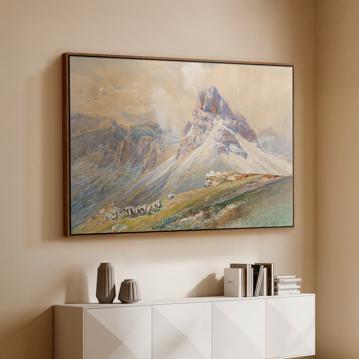 Walnut floater framed canvas of From the Dolomites, 1904 by Edward Theodore Compton, featuring an alpine scene with jagged rock formations and distant mountains above a console cabinet in a minimalist entryway.