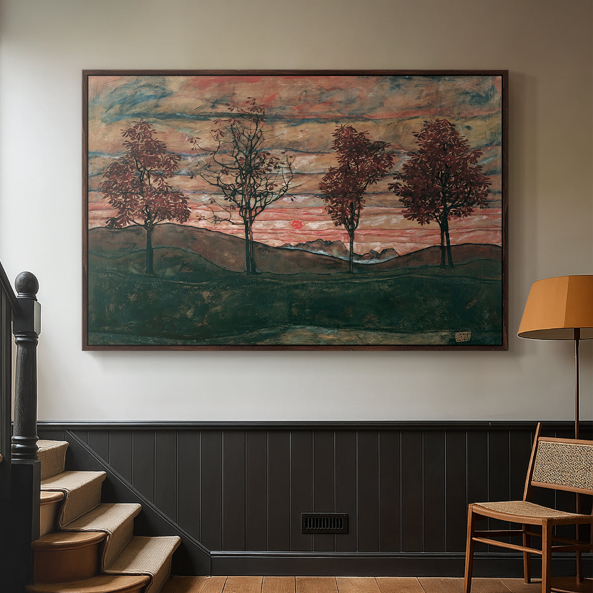 Walnut floater framed canvas featuring an expressionist landscape featuring isolated trees in field, displayed in a hallway near a staircase.