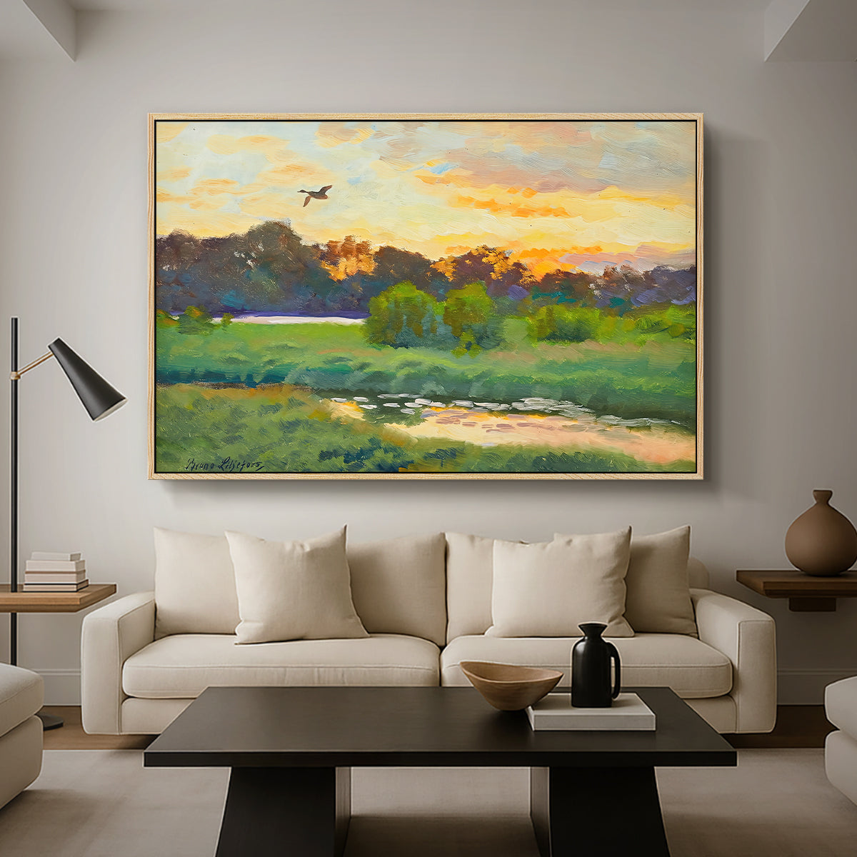 Flying Duck at Sunset, 1924 by Bruno Liljefors as a natural wood floater framed canvas featuring a wild duck flying over a sunset marsh with trees, displayed above a sofa in a modern living room.