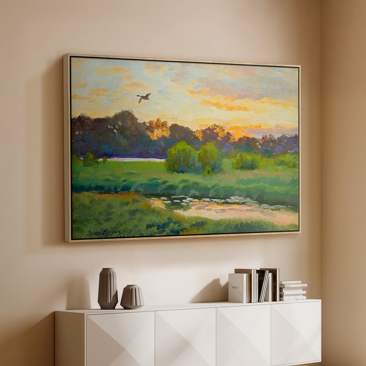 Natural wood floater framed canvas of Flying Duck at Sunset, 1924 by Bruno Liljefors, featuring a lone duck soaring over a glowing marshland above a console cabinet in a minimalist entryway.