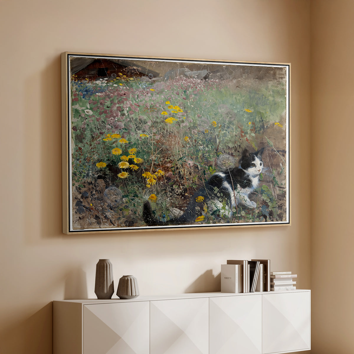 Natural wood floater framed canvas of Cat on a Flowery Meadow, 1887 by Bruno Liljefors, featuring a small cat resting among colorful flowers in grassy field above a console cabinet in a minimalist entryway.