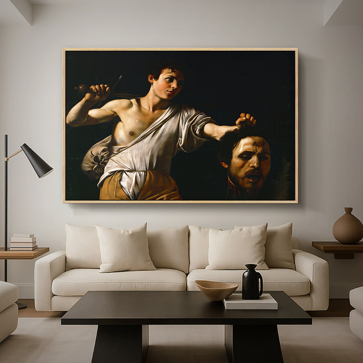 David with the Head of Goliath (Vienna Version), c. 1607 by Caravaggio as a natural wood floater framed canvas featuring a young David holding the severed head of Goliath against a dark background, displayed above a sofa in a modern living room.